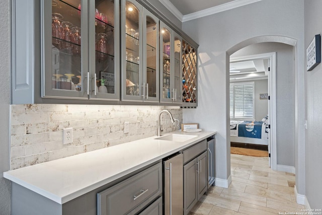 404 Matern Ct, Horseshoe Bay, TX 78657 - bar with tasteful backsplash, baseboards, arched walkways, ornamental molding, and a sink