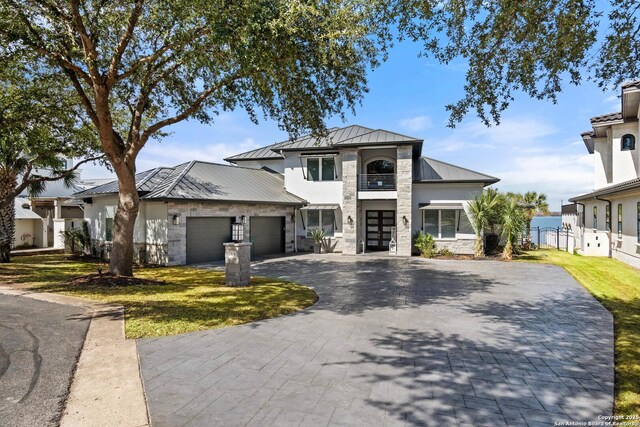 404 Matern Ct, Horseshoe Bay, TX 78657 - view of front of home with decorative driveway, an attached garage, a standing seam roof, metal roof, and stone siding