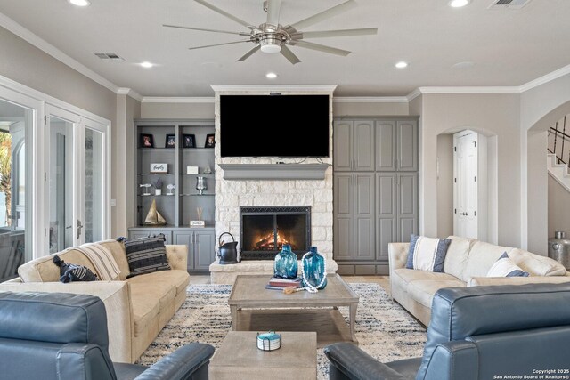404 Matern Ct, Horseshoe Bay, TX 78657 - living room with crown molding, arched walkways, visible vents, and a fireplace