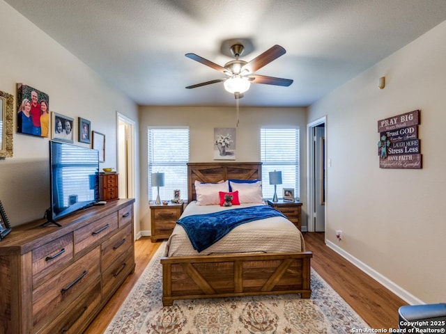 bedroom featuring light wood finished floors, baseboards, and a ceiling fan