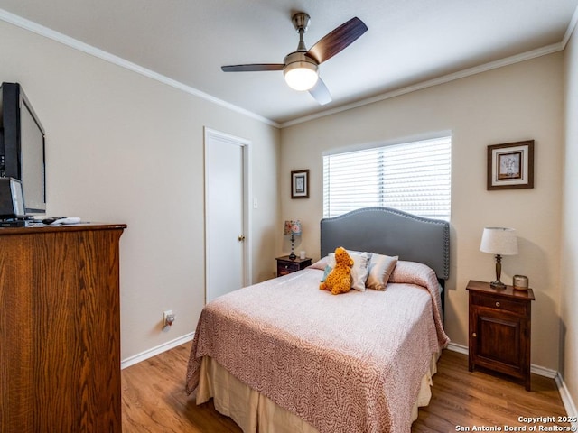 bedroom featuring light wood finished floors, baseboards, ornamental molding, and ceiling fan