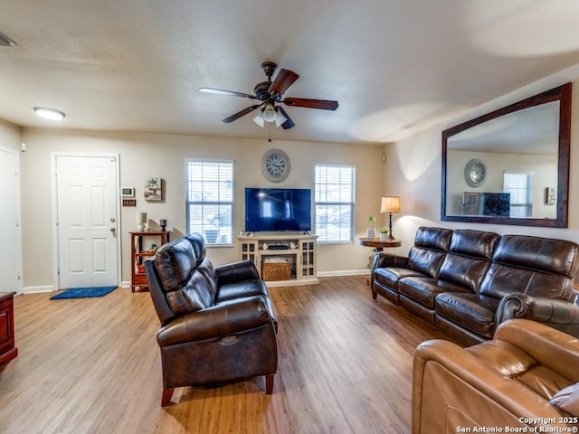 living area featuring ceiling fan, baseboards, and wood finished floors