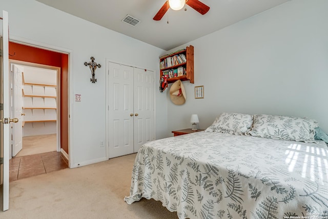 bedroom with a closet, visible vents, light carpet, ceiling fan, and baseboards