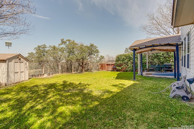 view of yard with an outbuilding, a storage unit, a patio area, and a fenced backyard