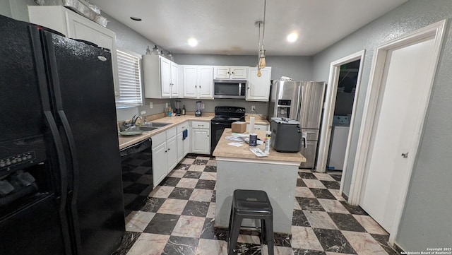 kitchen featuring black appliances, dark floors, a sink, and light countertops