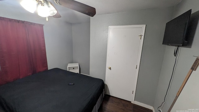 bedroom with dark wood-style floors and ceiling fan