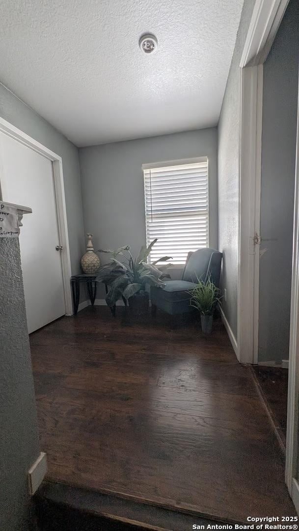 living area with a textured ceiling and wood finished floors