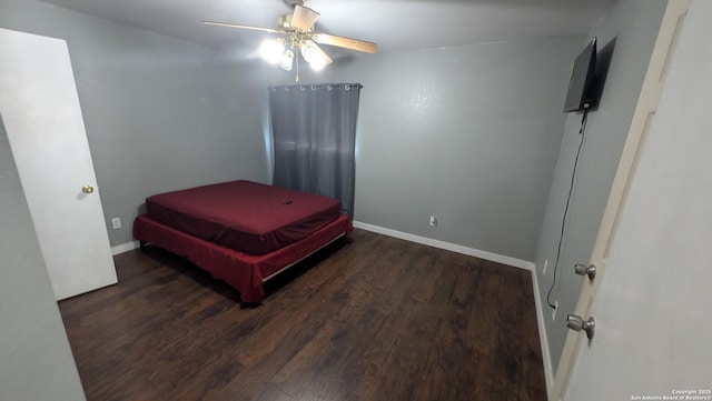 bedroom featuring wood finished floors, a ceiling fan, and baseboards