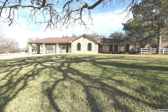 view of front of house featuring brick siding, a front yard, and fence