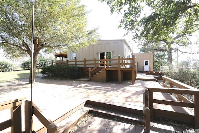 rear view of house featuring board and batten siding and a deck