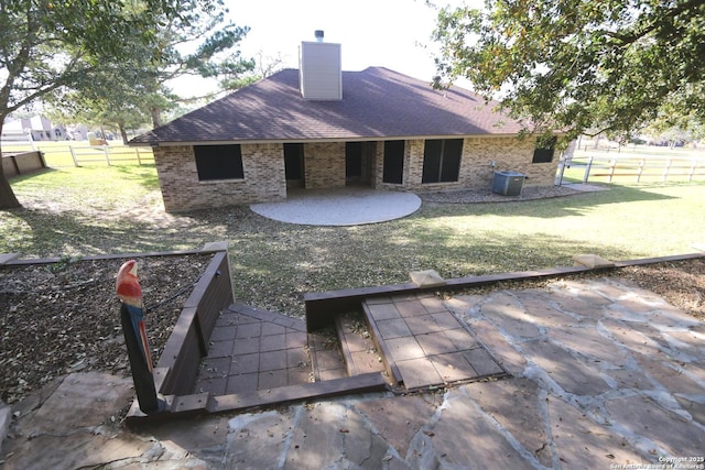 rear view of house featuring a patio, a chimney, fence, cooling unit, and brick siding