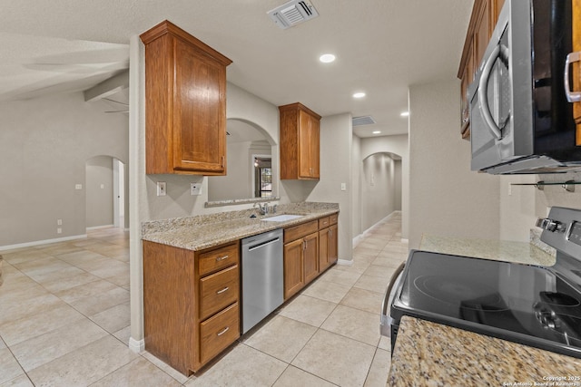 1300 Windmill Dr, La Vernia, TX 78121 - kitchen featuring brown cabinetry, visible vents, arched walkways, a sink, and appliances with stainless steel finishes