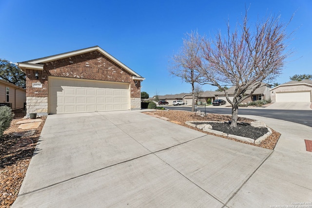 view of front facade with a garage, driveway, brick siding, and stone siding