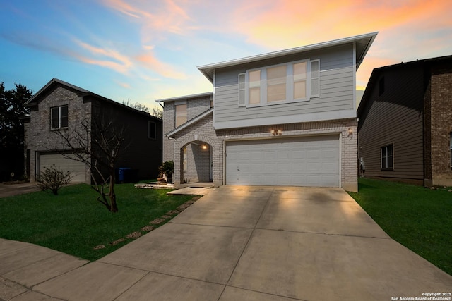 view of front facade featuring a garage, driveway, brick siding, and a front lawn