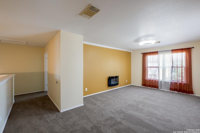 carpeted spare room with visible vents, a textured ceiling, and baseboards