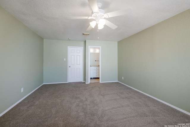 unfurnished bedroom featuring baseboards, visible vents, ensuite bathroom, carpet, and a textured ceiling