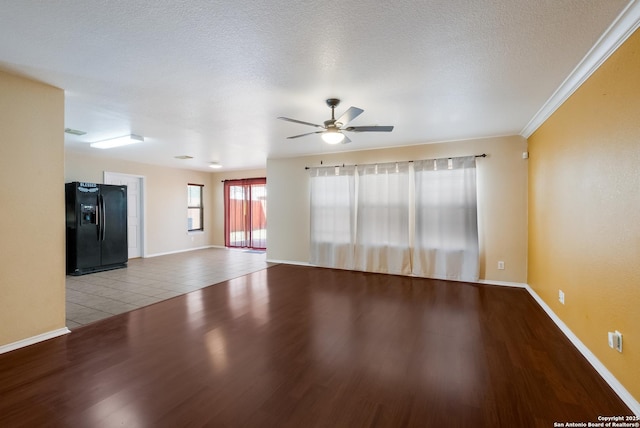 empty room with a ceiling fan, a textured ceiling, baseboards, and wood finished floors