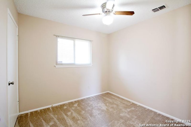 unfurnished room featuring baseboards, visible vents, ceiling fan, a textured ceiling, and carpet floors