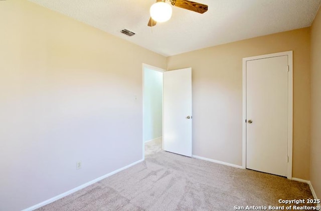 unfurnished bedroom featuring ceiling fan, carpet flooring, visible vents, and baseboards