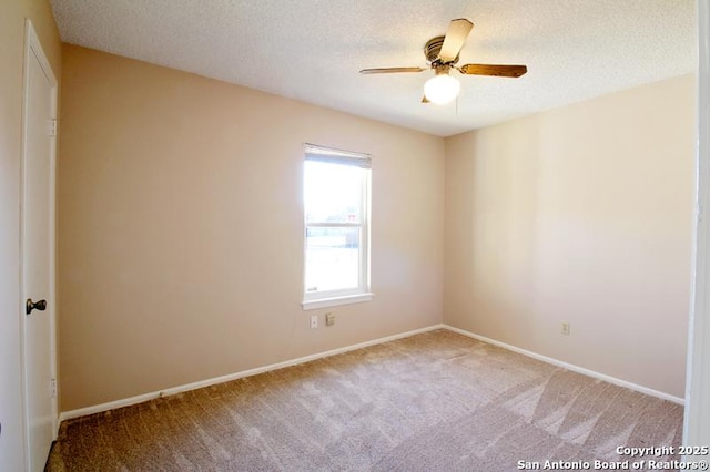 empty room with light carpet, ceiling fan, baseboards, and a textured ceiling