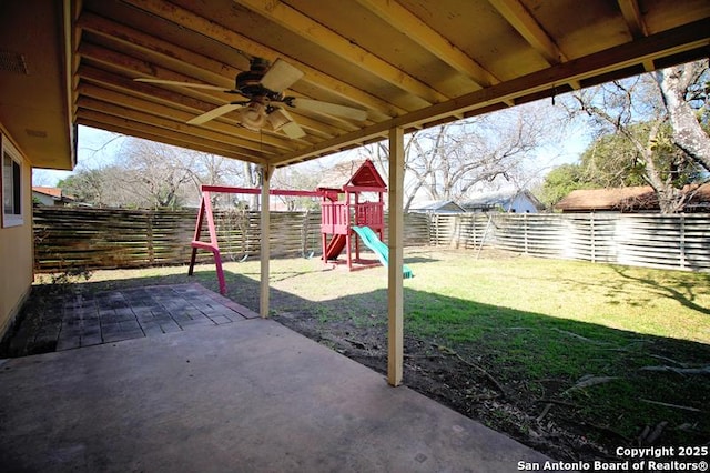 view of patio featuring a ceiling fan, a fenced backyard, and a playground