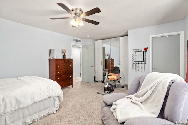 bedroom featuring a ceiling fan, a closet, visible vents, and light colored carpet