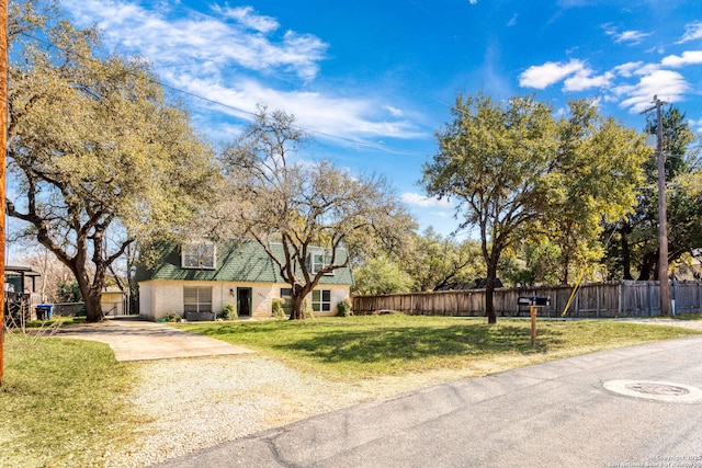 view of front of home with driveway, a front lawn, fence, and brick siding