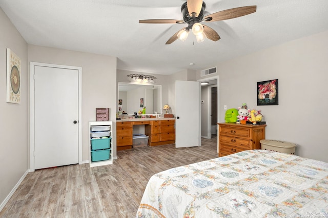 bedroom with ceiling fan, light wood-style flooring, visible vents, and baseboards