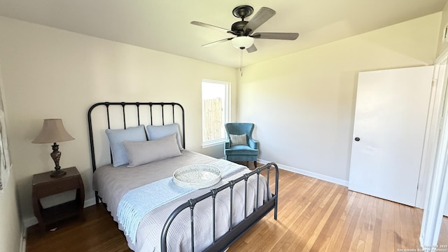 bedroom featuring baseboards, ceiling fan, and light wood-style floors