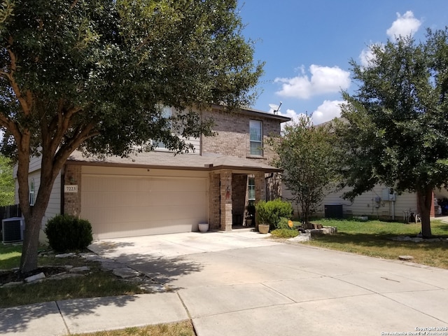 view of front of home with a garage, cooling unit, brick siding, and driveway