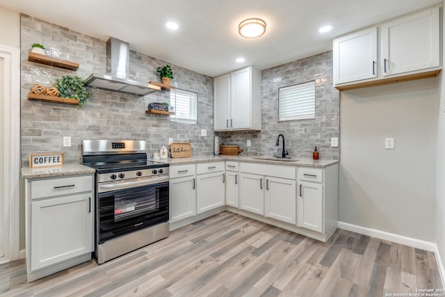 kitchen with a sink, wall chimney range hood, backsplash, stainless steel electric stove, and open shelves