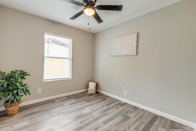 empty room with a ceiling fan, light wood-type flooring, and baseboards