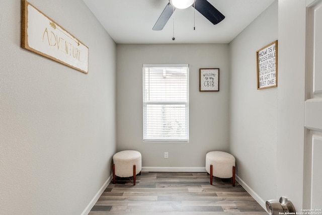 sitting room with light wood-style floors, ceiling fan, and baseboards