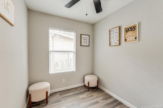 sitting room featuring ceiling fan, light wood-type flooring, and baseboards