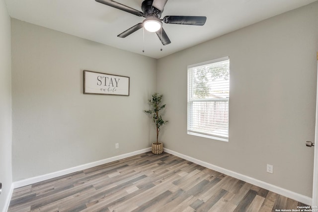 unfurnished room featuring a ceiling fan, light wood-style flooring, and baseboards