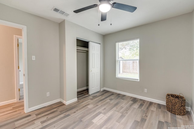 unfurnished bedroom featuring a closet, light wood-type flooring, visible vents, and baseboards