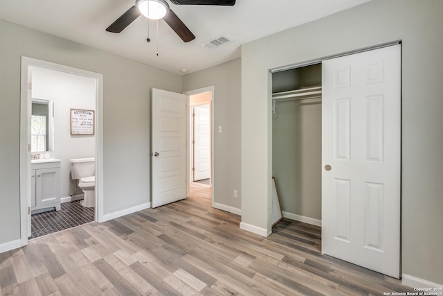 unfurnished bedroom featuring baseboards, light wood-style flooring, visible vents, and a closet