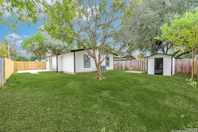 view of yard featuring a fenced backyard, a storage unit, cooling unit, and an outdoor structure