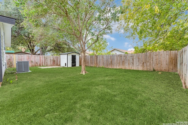 view of yard with central AC unit, a shed, an outdoor structure, and a fenced backyard