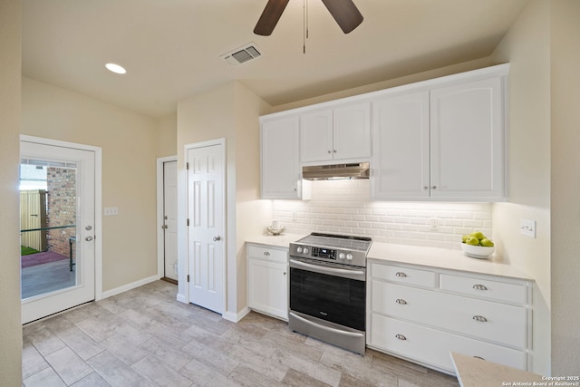 kitchen with tasteful backsplash, visible vents, under cabinet range hood, stainless steel range with electric cooktop, and white cabinetry