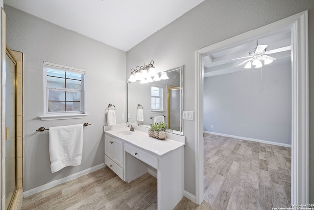 full bathroom featuring vanity, wood finished floors, baseboards, and a shower with door