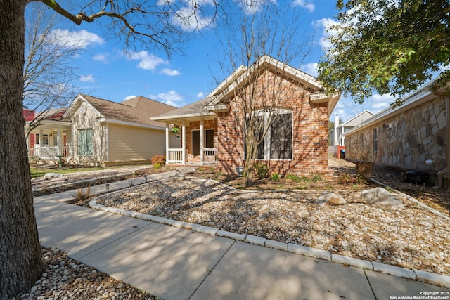 single story home featuring brick siding and a porch