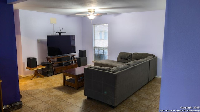 living room featuring ceiling fan and baseboards