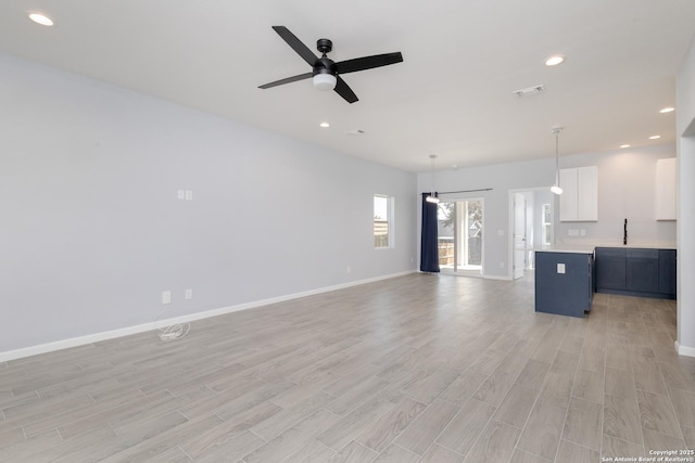 unfurnished living room featuring light wood-style floors, recessed lighting, visible vents, and baseboards