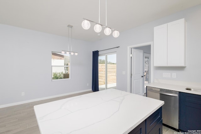 kitchen featuring decorative light fixtures, blue cabinetry, light wood finished floors, light stone countertops, and dishwasher