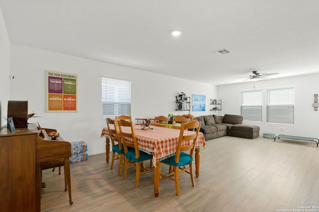 dining space featuring visible vents, ceiling fan, and light wood-style flooring