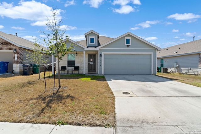 view of front facade featuring a garage, driveway, central AC, and a front yard