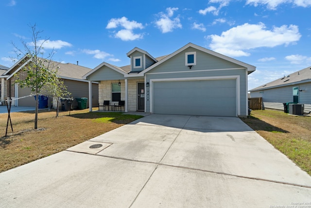 view of front of home featuring a front lawn, cooling unit, concrete driveway, and an attached garage