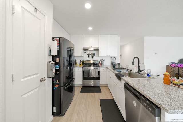 kitchen with stainless steel appliances, white cabinets, a sink, a peninsula, and under cabinet range hood