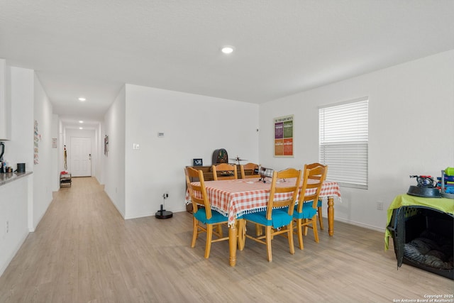 dining space with light wood-type flooring, baseboards, and recessed lighting